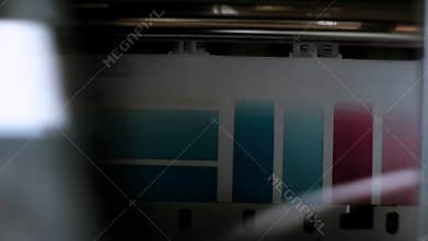 The process of printing a color inkjet printer in close-up. The rolles is rolling inside of device and printed a picture