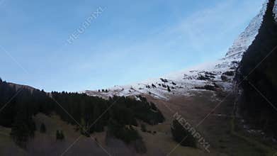 Drone footage of the rolling hills and snow-capped mountains with dense forest in Alto Adige, Italy