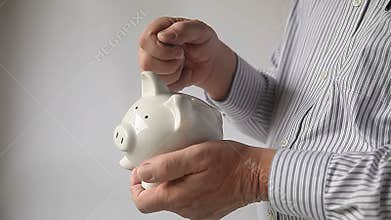 Businessman puts pennies in piggy bank