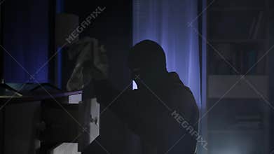 a male intruder rummages through other people things in search of valuables