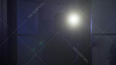 trespassing, dangerous male thief in balaclava with flashlight enters property looking for valuables