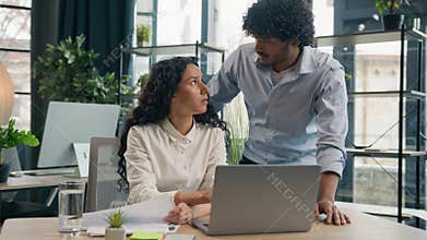 Arabian man business coach helping Hispanic woman intern businessman mentor consult colleague businesswoman teaching