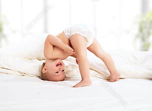 Happy baby child playing in bed