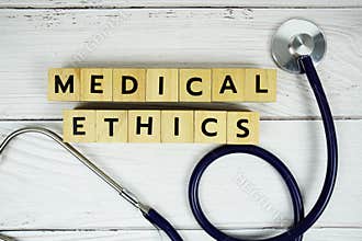 Medical Ethics with wooden blocks alphabet letters and stethoscope on wooden background, Healthy and wellness concept