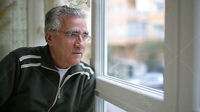 Senior man looking through window
