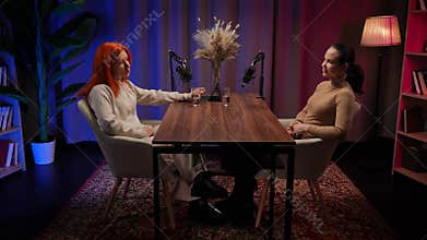 Two Influencers of women being interviewed in a loft-style podcast studio