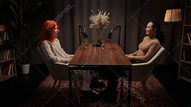 Two Influencers of women being interviewed in a loft-style podcast studio
