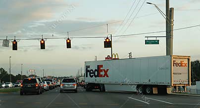 Central Florida, U.S - Nov 11, 2024 - Traffic standstill at a busy intersection, with a FedEx truck prominent in the scene