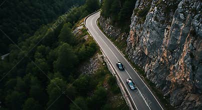 Driving on Scenic Mountain Road with Cars Amidst Lush Greenery