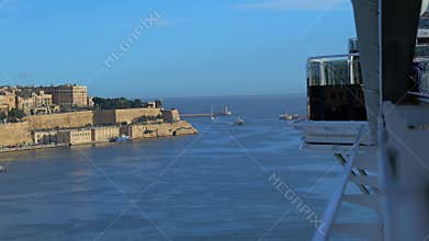 Cruise ship sailing through Valletta Grand Harbour with historic fortifications