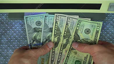 Man check dollars on bills detector with UV light. Man hands took dollars into bill detector. Checking banknotes in a UV light