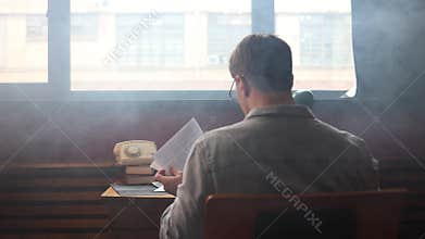 Young author thinking intensely in vintage office,