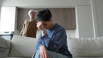 Silent scared wife cries on couch, angry husband screams shames accuses affair. Marriage crisis