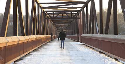 Man walking over footbridge