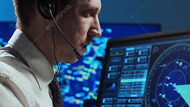 Professional air traffic controller in the control tower. Aircraft control officer works using radar, computer