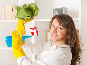 Beautiful young woman cleaning her house