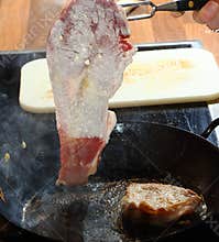 Flour coated beef frying in hot grease