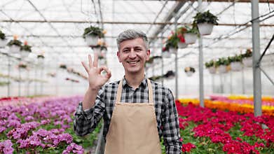 Greenhouse Worker with a Positive Sign
