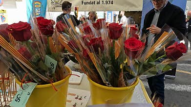 Barcelona, Spain-June 24, 2025. Florist selling roses and bouquets at a market stall decorated with catalan flag colors for saint
