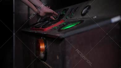 A woman presses buttons on an old control panel in a subway car, quest.