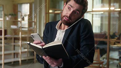 Caucasian business man talking mobile phone adviser multitasking businessman in office using gadgets notebook planning