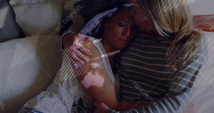 Woman leaning into partner for reassurance on sofa in health clip, with heart icon floating