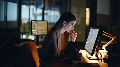 Financial analyst working computer at night workstation with real time stocks