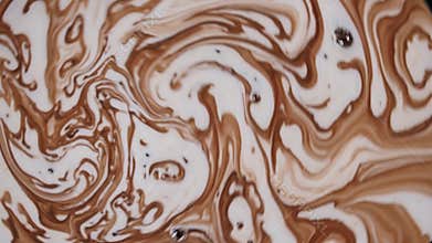 Milk and chocolate mixing together, creating mesmerizing swirls and bubbles, perfect for projects related to food, beverages, or