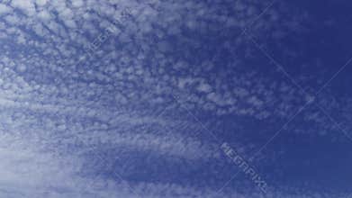 Light, cirrus clouds scattered across a bright blue sky
