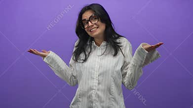 Woman smiling shrugging hand palms up wearing glasses in studio; uncertainty doubt hesitation confusion