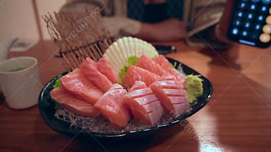 Close-up of fresh raw salmon sashimi slices on a traditional Japanese platter.
