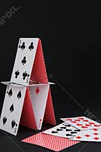 House of playing cards on black background