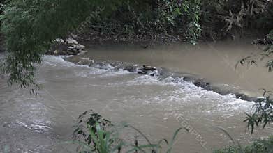 Water stream in the river flowing through stone.