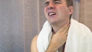 man shaves his face without cream or foam, experiencing pain and suffering. sad man shaves in front of a mirror in the