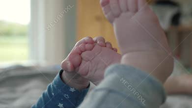 Little hand playing with feet