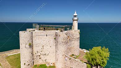 Drone landscape view of Santa Ana Castle-Lighthouse overlooking the blue sea on a sunny day