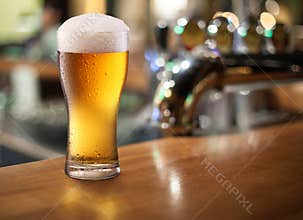 Photo of cold beer glass on a bar.