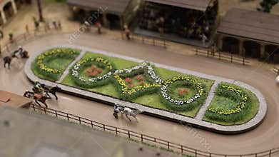 Small scale replica of a horse racing track