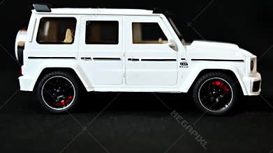 Side Profile of White Mercedes-Benz G-Class Toy SUV with Black Accents on Dark Background