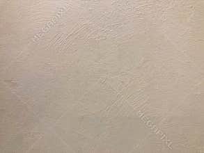 Image of a textured, light tan or beige wall with a subtle linear pattern, possibly brushed or faux finish Soft shadows