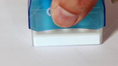 Hand stamp the word Cancel with a red stamp on white paper.