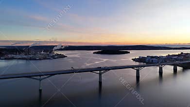 Aerial view of Sundsvall bridge, harbor, smokestacks, and golden sky reflection