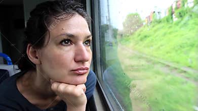 Woman sits in train near window during movement