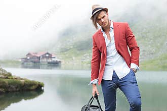 Fashion male model posing in front of a lake