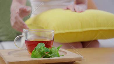 Closeup hands of woman pick tea of cup for enjoying sitting on sofa with satisfied in living room at home, close-up hands of woman