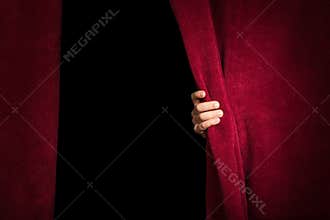 Hand appearing beneath the curtain.