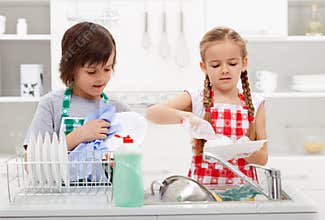 Kids washing the dishes in the kitchen