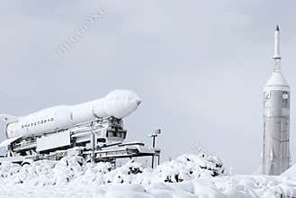 Rocket and shuttle covered in snow at a space museum