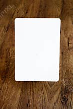Sheet of paper with rounded borders above the old wooden background, open aperture