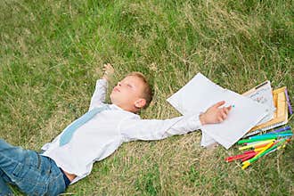 Schoolboy sleeping on the grass
